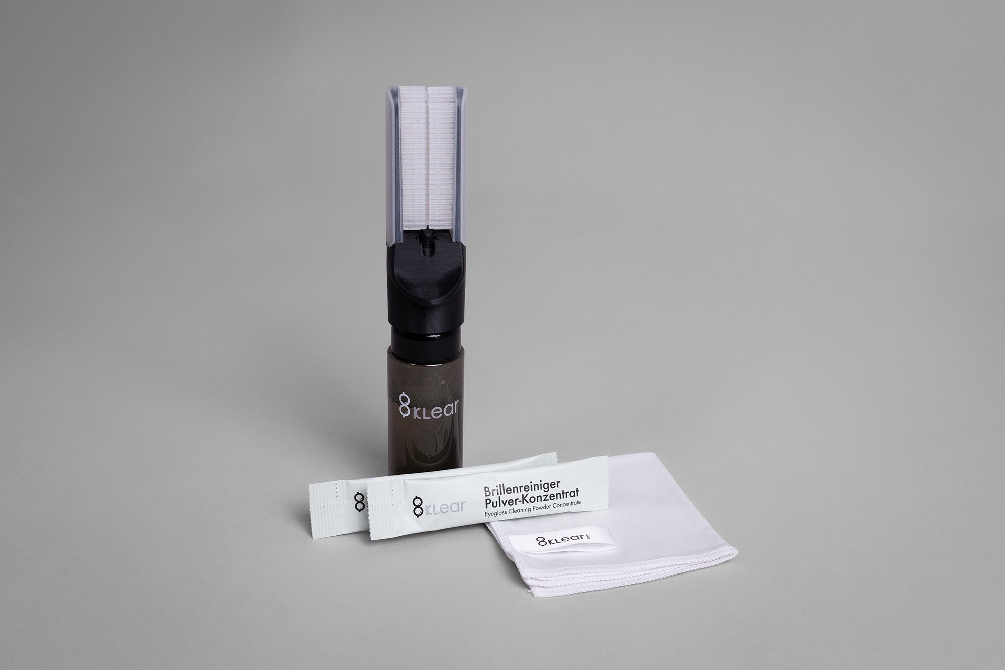 Prototyp des 8klear Brillenreinigers mit zwei Pulversticks und Mikrofasertuch